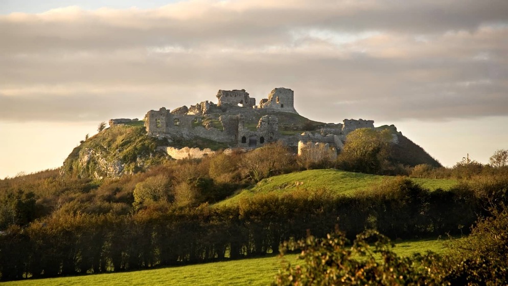 Ruins of the Rock of Dunamase on a hilltop above green countryside in County Laois.