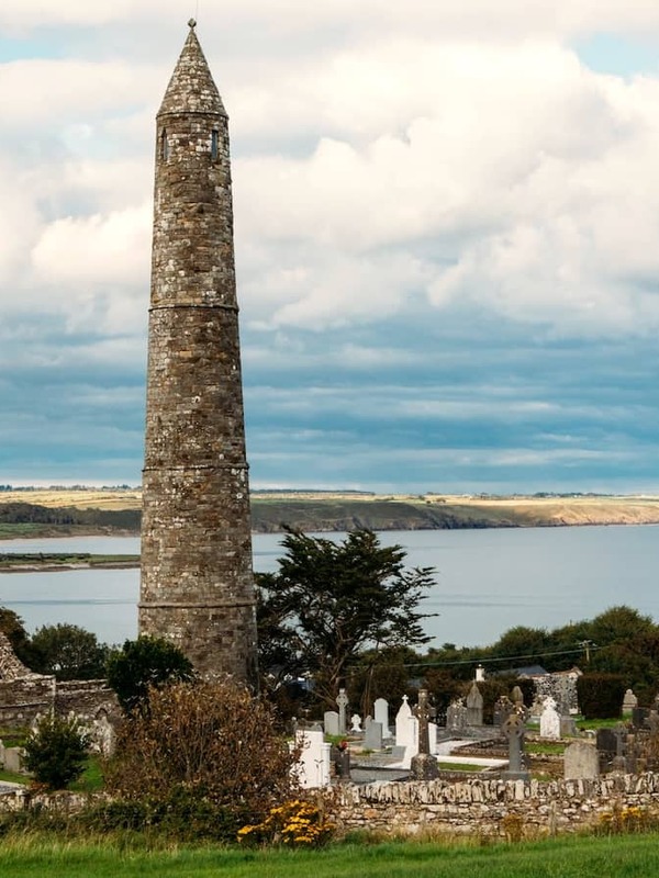 Ardmore Round Tower in County Waterford, rising above an old graveyard with sweeping views of the coastline.
