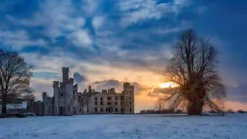 Ducketts Grove in County Carlow at winter sunset, with the gothic ruin set against a dramatic sky and snow-covered grounds.