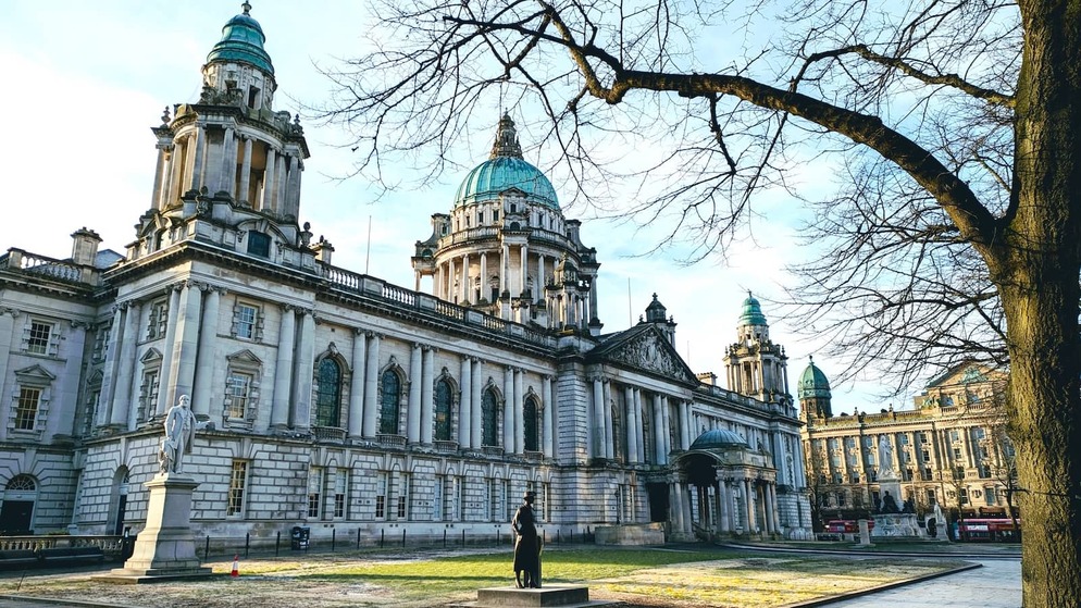Grand domed Belfast City Hall with statues and trees in Donegall Square, County Antrim.
