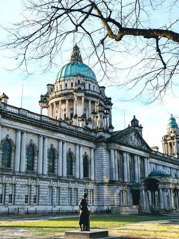 Grand domed Belfast City Hall with statues and trees in Donegall Square, County Antrim.
