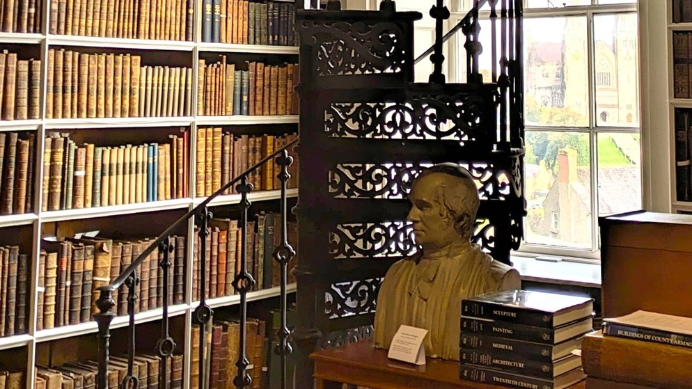Bust, spiral staircase and shelves of antique books in the historic Robinson Library, Armagh.