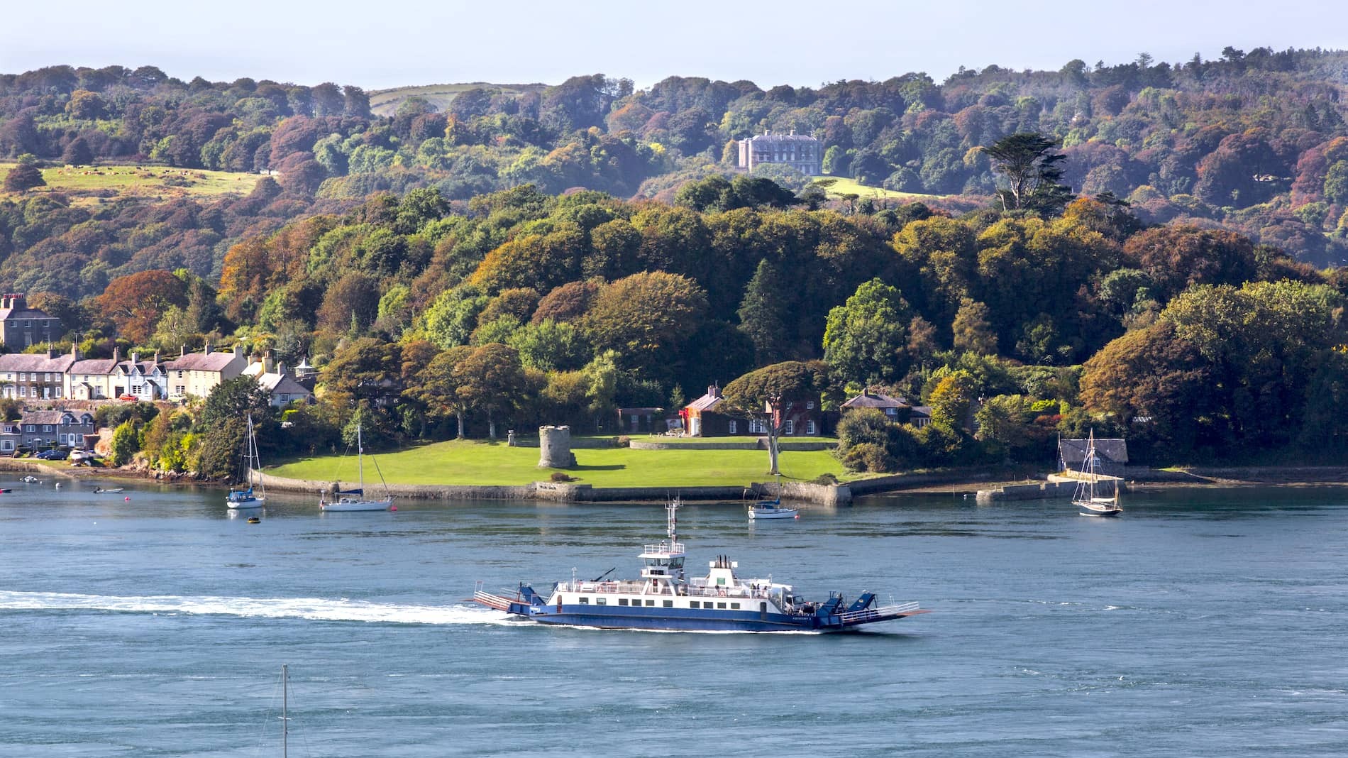 Traditional fishing boats in Portaferry Harbour with Strangford Lough and Mourne Mountains in the background.