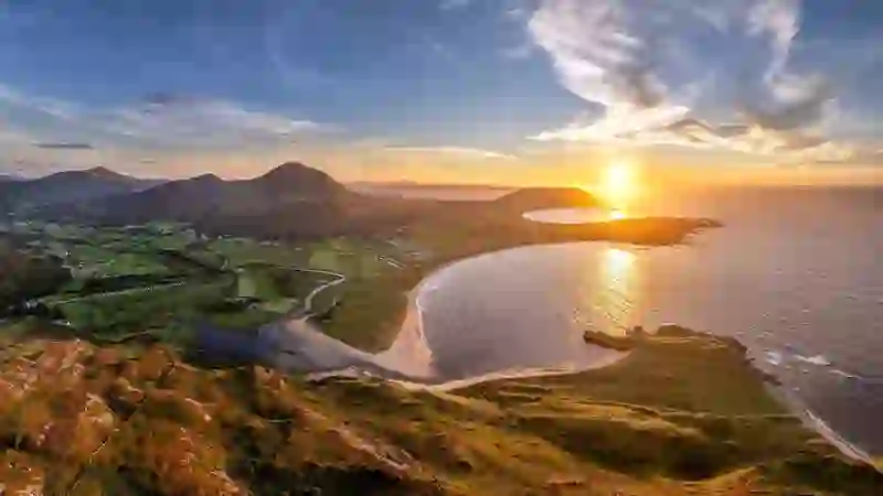 Panoramic sunset over Tullagh Bay with rolling hills, beaches, and farmland on the Inishowen Peninsula, County Donegal.
