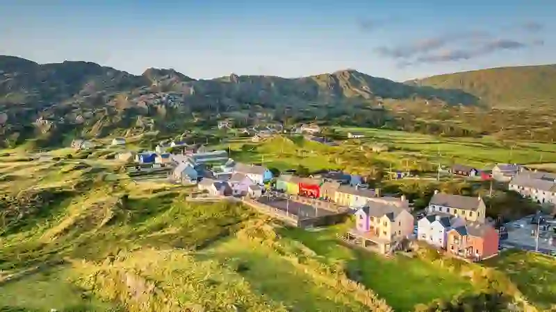 Aerial view of colourful houses in Allihies village nestled among green hills on the Beara Peninsula, County Cork.