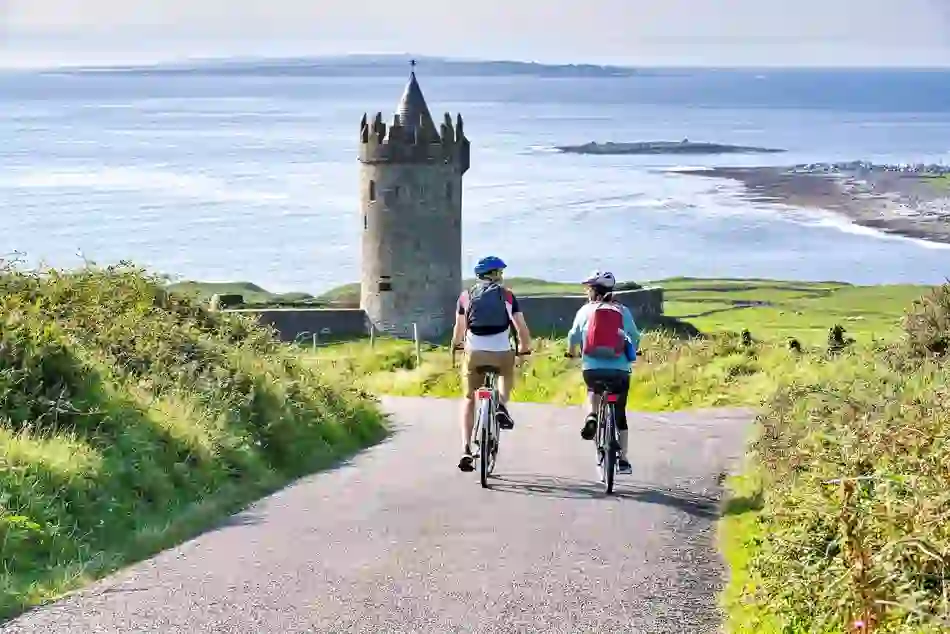 Panoramic view of winding coastal road through green hills overlooking the Atlantic Ocean on the Wild Atlantic Way.