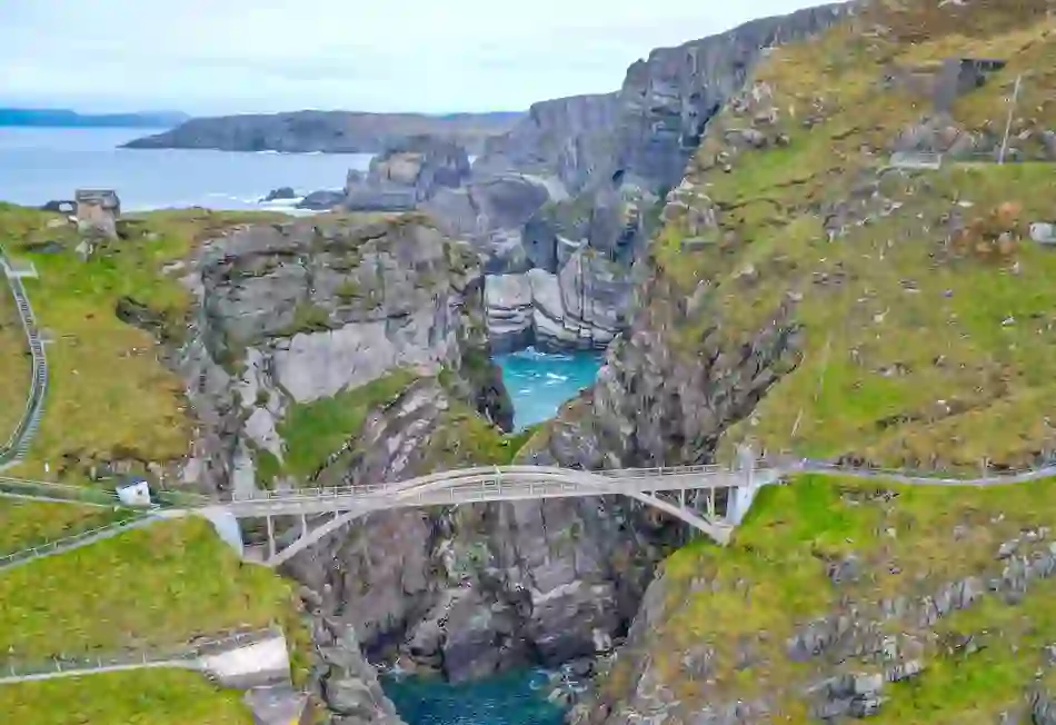 Aerial view of the dramatic Mizen Head cliffs with a pedestrian bridge spanning a deep sea gorge along the Wild Atlantic Way.