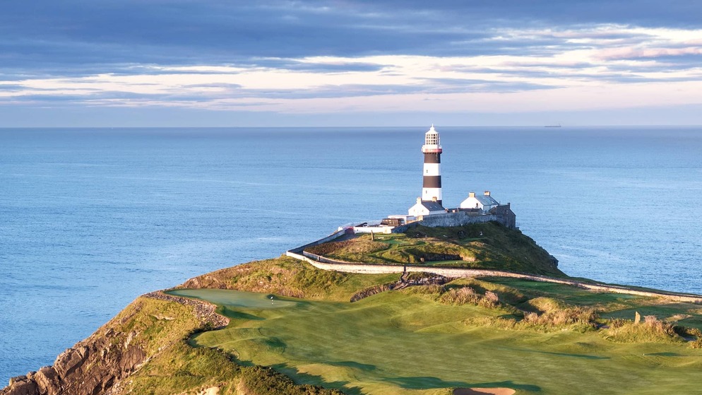 Striking Old Head of Kinsale lighthouse overlooking dramatic Atlantic coastline in County Cork.