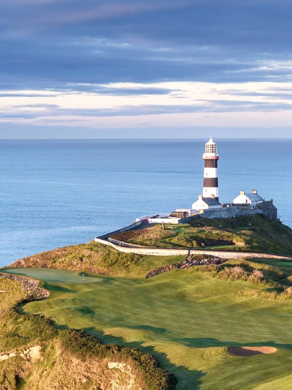 Striking Old Head of Kinsale lighthouse overlooking dramatic Atlantic coastline in County Cork.