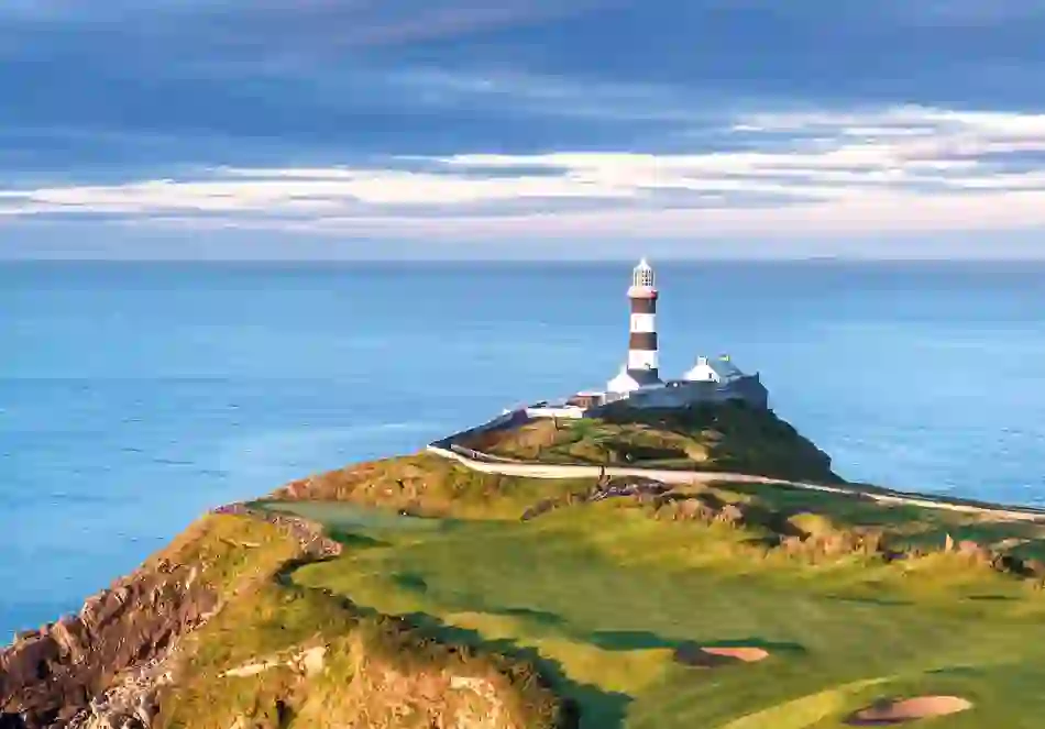 Striking Old Head of Kinsale lighthouse overlooking dramatic Atlantic coastline in County Cork.