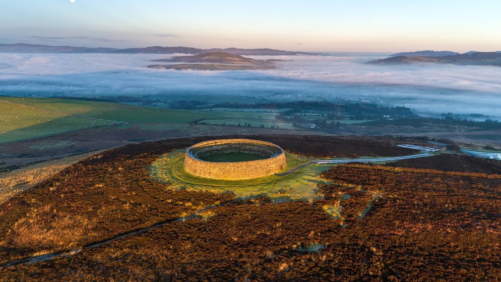 Ancient stone ring fort on a hilltop overlooking misty valleys and distant hills in Inishowen, County Donegal.