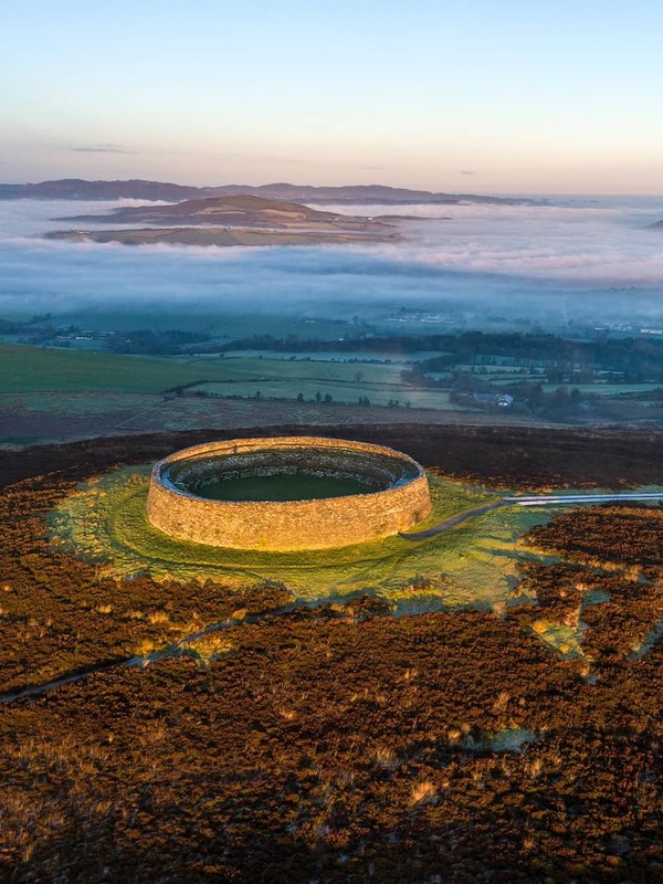 Ancient stone ring fort on a hilltop overlooking misty valleys and distant hills in Inishowen, County Donegal.