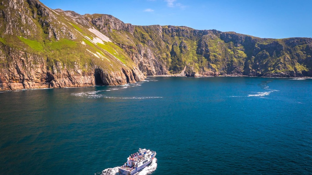 Tour boat cruises below the towering Slieve League cliffs on the Wild Atlantic Way in County Donegal.