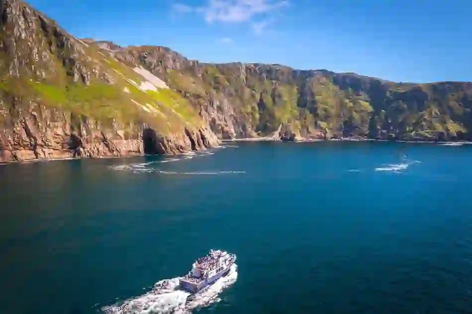 Tour boat cruises below the towering Slieve League cliffs on the Wild Atlantic Way in County Donegal.