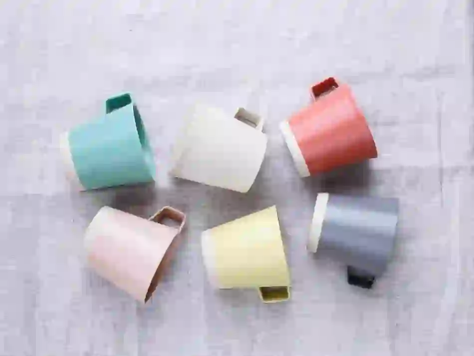 Set of pastel-toned mugs arranged in a circular pattern on linen, handmade by Arran Street East in Dublin.