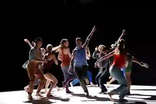 Contemporary dance group performing on stage under dramatic lighting in Dublin.