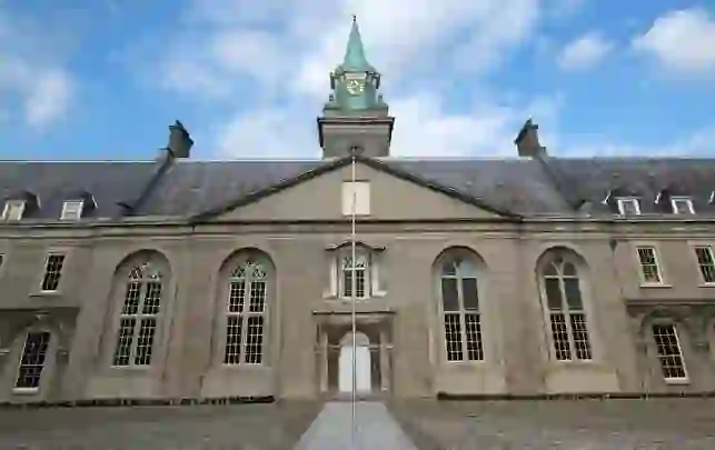 Façade of the Royal Hospital Kilmainham in Dublin with clock tower against a blue sky.