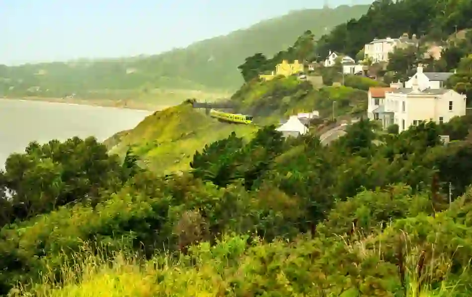 DART train passing along the coast near Killiney with houses overlooking Dublin Bay.