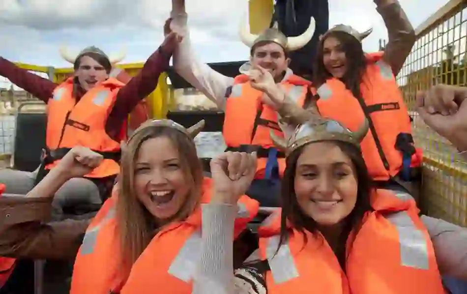 Smiling group wearing Viking helmets and life jackets on the Dublin Viking Splash Tour.