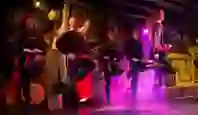 Energetic Irish dancers performing in a traditional setting with red and purple stage lighting at Johnnie Fox’s Pub in Dublin.