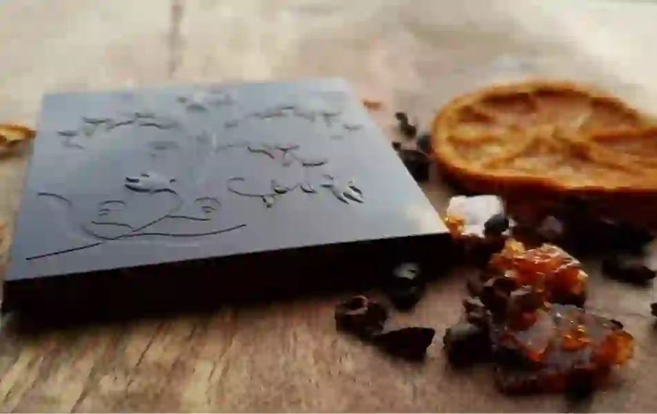 Decorative dark chocolate bar with orange slice and caramel shards beside it at NearyNógs, County Down.