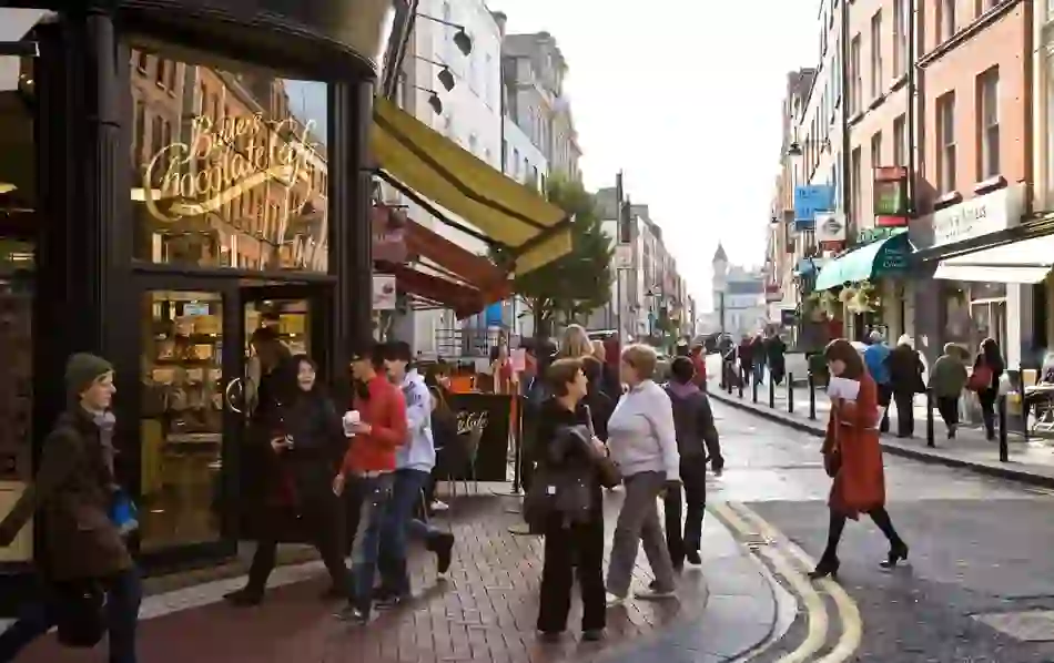 Crowds passing Butlers Chocolate Café on a busy Dublin street.