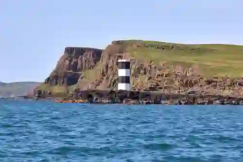 Rue Point Lighthouse on Rathlin Island, standing beside rugged cliffs along the Antrim coast.