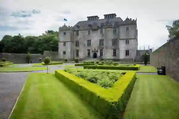 Formal hedged gardens leading to the grand façade of Portumna Castle, County Galway.