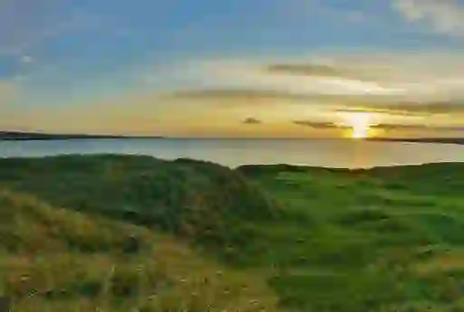 Lahinch Golf Course, County Clare, with sunset over Atlantic Ocean and links fairways.