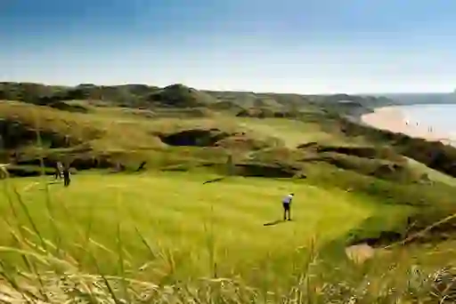 Ballybunion Golf Club, County Kerry, with golfers playing beside sandy beach and dunes.