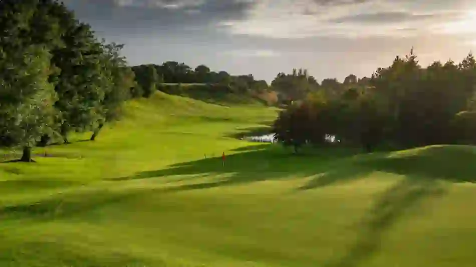 Esker Hills Golf Course, County Offaly, with rolling greens, trees, and evening sunlight.