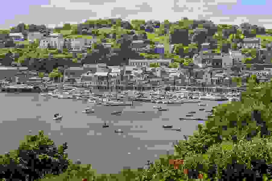 Yachts moored in colourful Kinsale Harbour with lush green hills in the background, County Cork