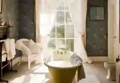 Vintage clawfoot bath under a tall window with white curtains in Hilton Park, Monagahan.