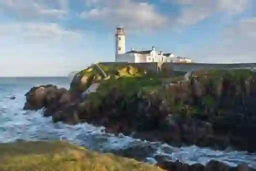 Fanad Head Lighthouse perched on a rocky headland above crashing waves on Donegal’s Fanad Peninsula.