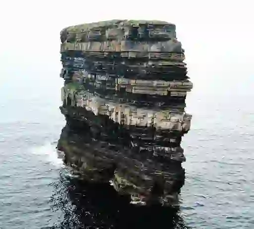 The towering sea stack of Downpatrick Head in County Mayo, its layered rock face rising from the Atlantic Ocean.