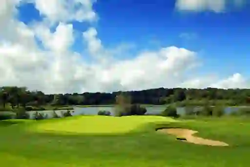 Golf green and sand bunker beside a lake, representing golfer Darren Clarke.