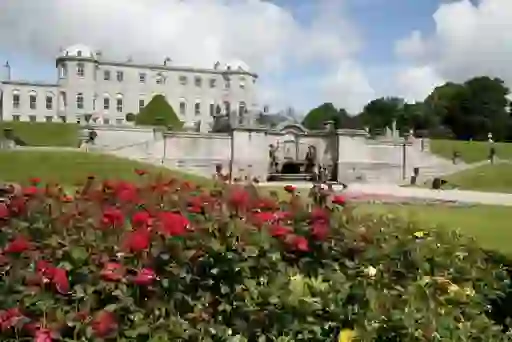Grand mansion with formal rose garden and landscaped estate grounds.