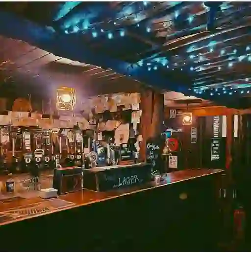 Rustic wooden bar with fairy lights and historic notes on display inside Grace Neill’s pub in Donaghadee, County Down.