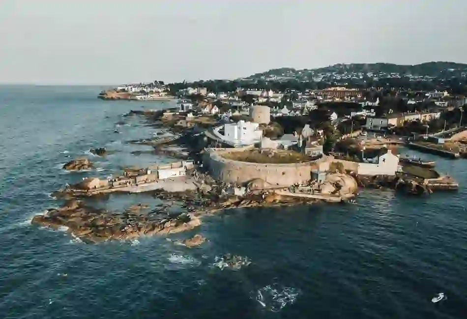 Aerial view of James Joyce Tower and Museum in Sandycove, County Dublin, with rocky coastline and surrounding homes.
