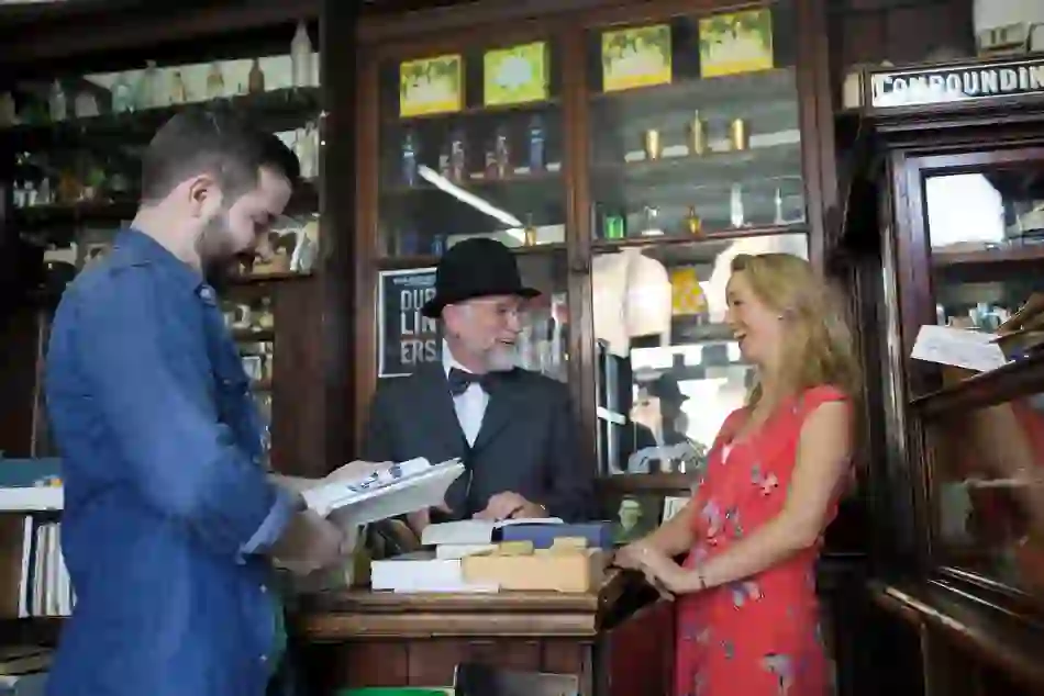 Visitors inside Sweny’s Pharmacy, Dublin, engaging with a James Joyce interpreter in a historic literary setting.