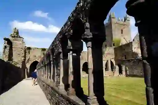 Ruins of Jerpoint Abbey with stone arches and medieval tower in Kilkenny.
