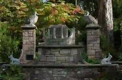 Ornate stone sculpture of Noah’s Ark with animal carvings in the lush gardens of Mount Stewart.