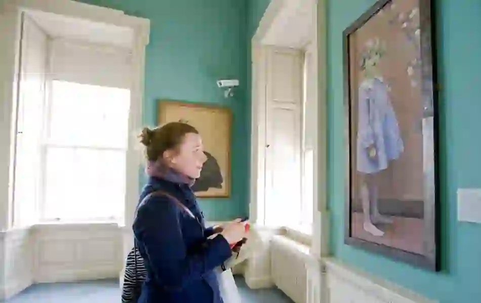Visitor viewing a portrait in the art gallery at the Hunt Museum in Limerick.