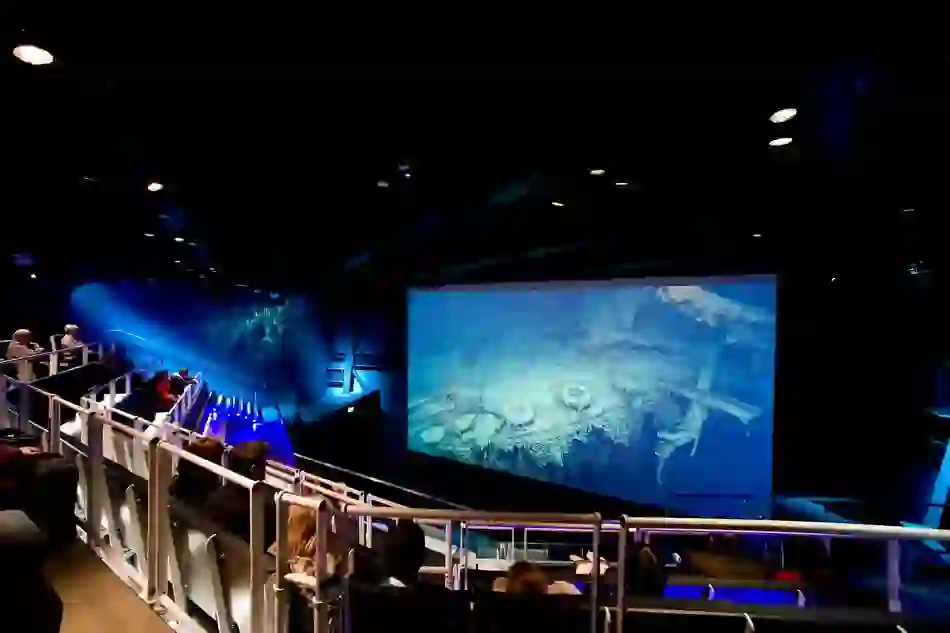 Visitors watch footage of the Titanic wreck in a dimly lit theatre at Titanic Belfast.