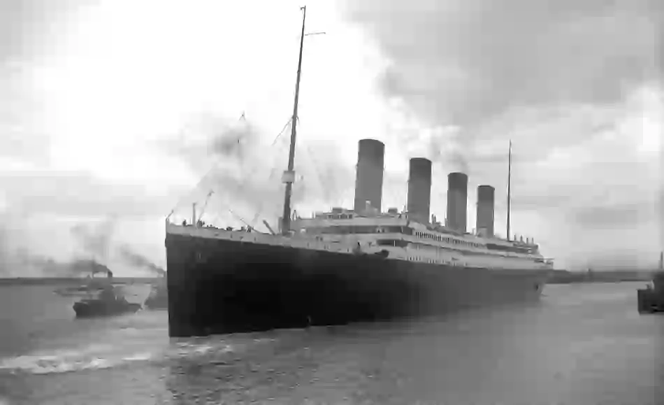 RMS Titanic departing Southampton, with smoke billowing from its funnels as it sails into open water.
