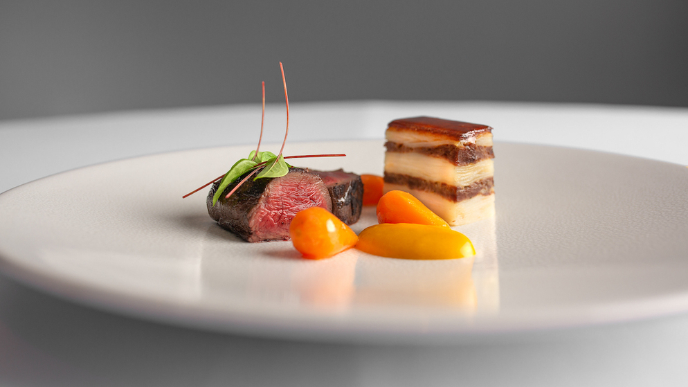 Fine dining dish of beef with layered potato and vegetables at a Michelin star restaurant in Ireland.