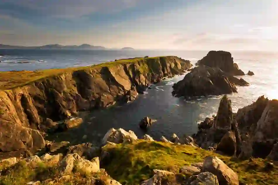 Golden light casts shadows over rugged cliffs at Malin Head in County Donegal, Ireland’s northern tip.