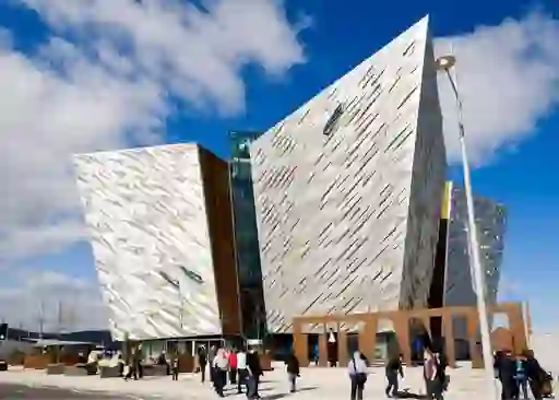 Titanic Belfast museum with striking angular design and visitors outside on a sunny day