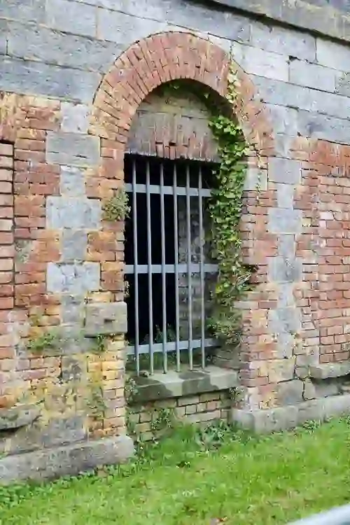 Close-up of barred prison window framed by red and grey stone at Spike Island.