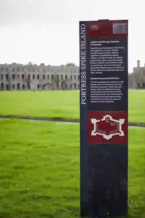 Information sign for Fortress Spike Island with parade ground in the background.